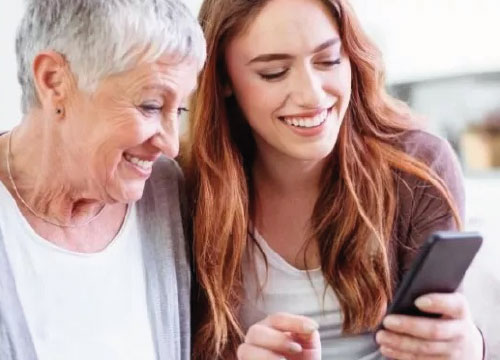 Mulheres sorriem para um telemóvel